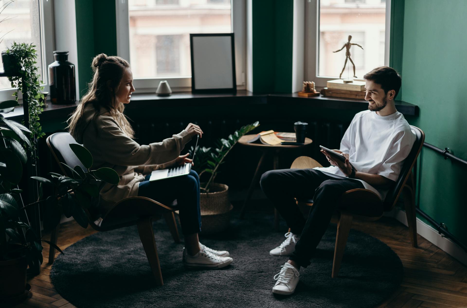 Two colleagues reviewing a delivery dashboard on a laptop in a softly lit workspace